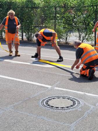 Mitarbeiter bringt gelbe Straßenmarkierung an 